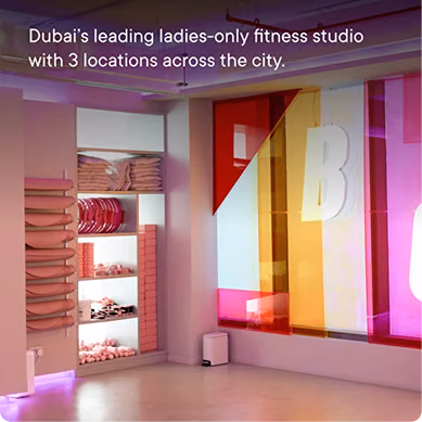 Interior of the BODIFY women-only fitness studio featuring a spacious workout area, neatly organized fitness equipment, and a colorful branded wall design.
