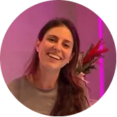 Photo of Maddalena, a BODIFY client, smiling in soft pink studio lighting