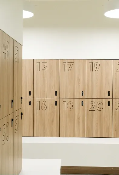 Light wood lockers lined up in the clean changing room of the fitness space