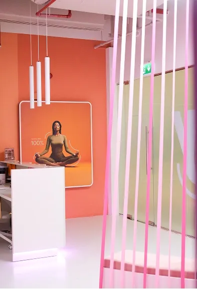 Orange wellness corner with a meditation poster and soft lighting inside the BODIFY club