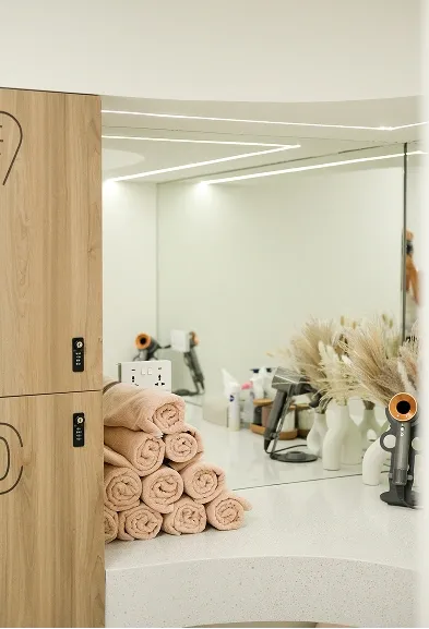 Folded towels and beauty tools arranged on a vanity counter in the wellness area