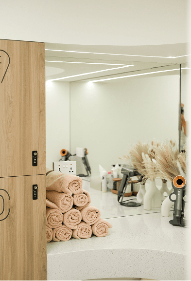 Folded towels and beauty tools arranged on a vanity counter in the wellness area