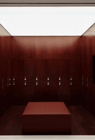 Dark wood lockers and a central bench in the changing room at BODIFY