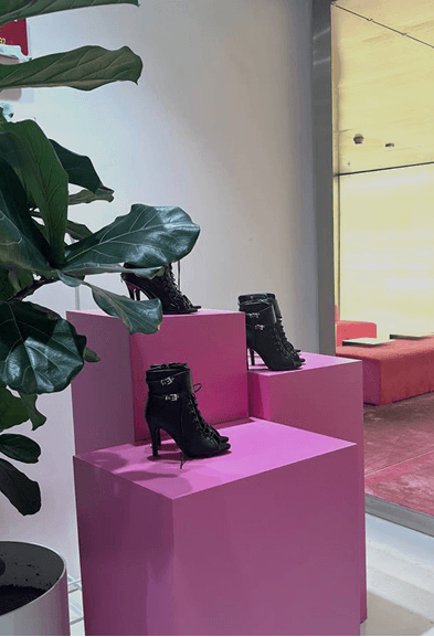 Black high heels displayed on pink pedestals in the stylish interior of BODIFY