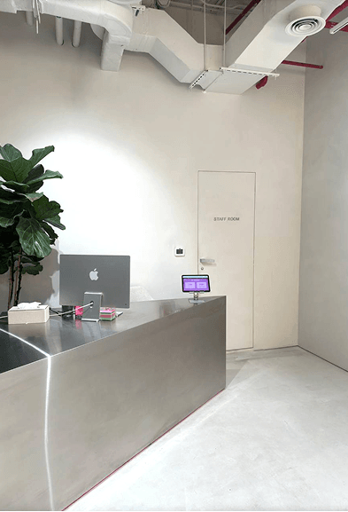 Minimalist reception desk in the entrance area of the BODIFY fitness studio