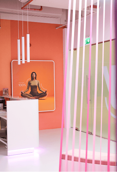 Orange wellness corner with a meditation poster and soft lighting inside the BODIFY club