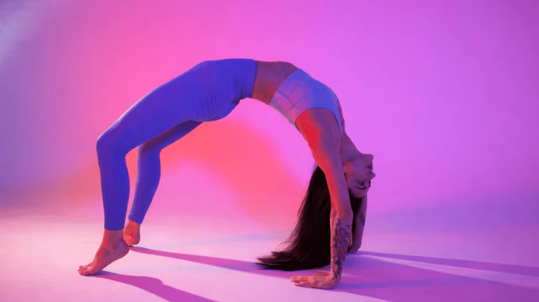 Woman performing a deep backbend stretch in a studio, demonstrating flexibility and self stretching practice