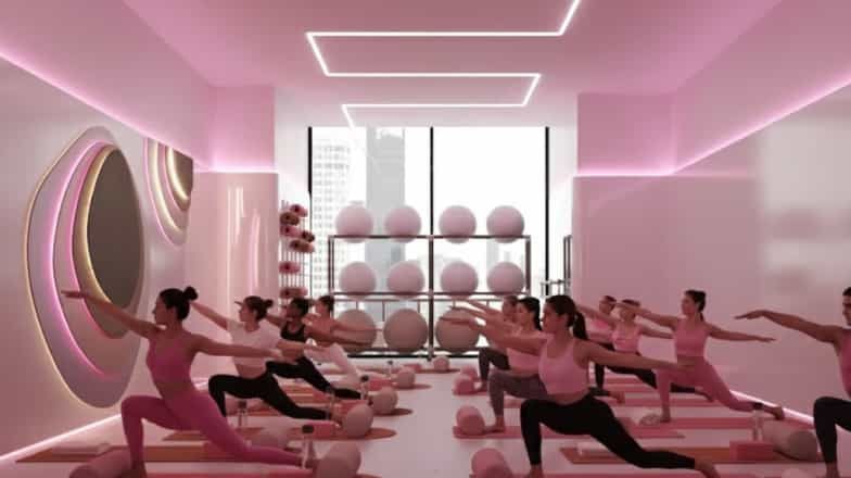 Group fitness class with people performing lunges in a modern pink-lit studio with exercise balls and mirrors