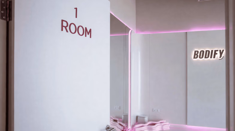 Entrance to a private training room in a boutique fitness studio with soft lighting