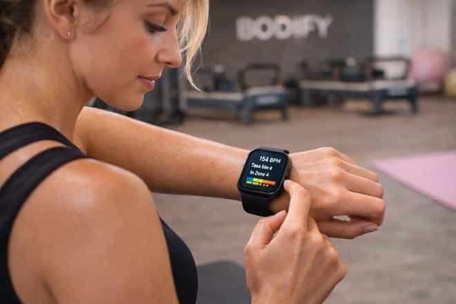 Woman checking her smartwatch heart rate during a cardio workout at BODIFY Dubai